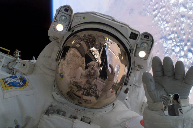 JAXA Astronaut Soichi Noguchi waves at his spacewalking crewmate, Astronaut Steve Robinson